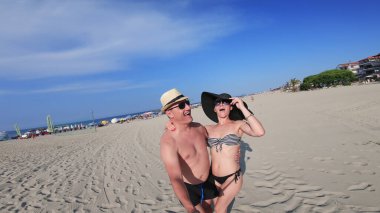 Kumsalda orta yaşlı bir çift etrafında dönerek eğleniyor.