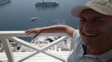 Fira, Santorini manzaralı lüks otel kafesinde yaz tatilinin tadını çıkaran bir adam. Avrupa 'ya seyahat. Turist yaşam tarzı.