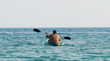 Halkidiki, Yunanistan - 25 Haziran 2018: Aile denizde kürek çeken bir teknede eğleniyor