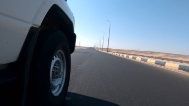 Çölde bir arazi aracı sürerken düşük açılı çekim.