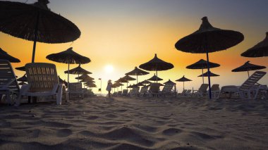 Gün batımına karşı güneş gözlüklü ve güneşli plaj, seyahat kavramı arka planı