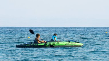 Halkidiki, Yunanistan - 25 Haziran 2018: Aile denizde kürek çeken bir teknede eğleniyor