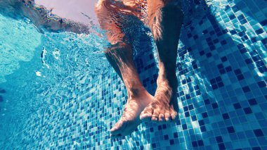 Gevşemeden önce bacaklarını havuzda sallayan adamların yavaş hareketleri.