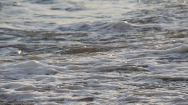 Dalgaların yakın çekim sahili ıslak kumlar kuruyor, sinematik dof