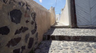 Romantik Santorini adasını ziyaret eden kadınlar bahar çiçeklerinin kokusunu alırlar.