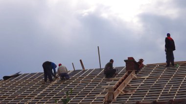 Makedonya 'nın Kocani kenti - 10 Ekim 2018: Yeni bir evin çatı örtüsü ve çıkıntıları veya merdiveni üzerinde çalışan inşaat ekibi