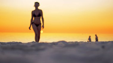 Bikini plaj deniz suyu ile arka plan, seçici odak günbatımında yaz doğru yürürken uygun erkek sinema görünümünü