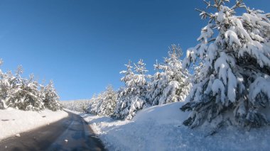 Kış mevsiminde kar yağarken karla kaplı bir yolun manzarası - Pov, ilk kişi
