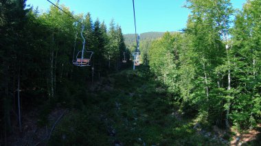 Dağ sandalyesi bir yaz günü ormana yükselir.