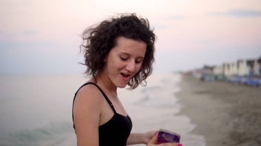 Gün batımında güneşli sahilde dans eden tatlı kız.