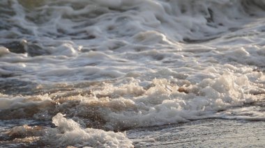 Dalgaların yakın çekim sahili ıslak kumlar kuruyor, sinematik dof