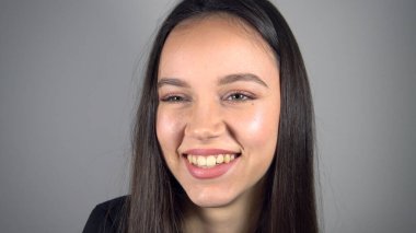 Neşeli baştan çıkarıcı genç bayan kameraya olumlu gülümsüyor.