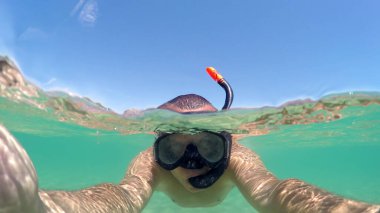 Su yüzeyinde yüzen adamın selfie 'si. Gopro kubbesi atışı