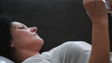 Güzel kız kanepede uzanıp kitap okuyor.