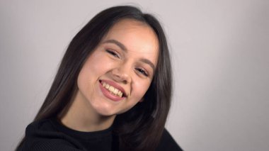 Neşeli baştan çıkarıcı genç bayan kameraya olumlu gülümsüyor.