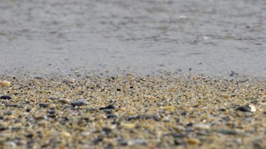 Deniz kenarındaki çakıl taşları. Mavi denizin ipeksi dalgaları