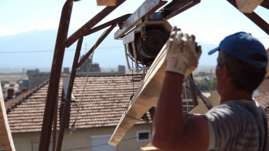 Makedonya 'nın Kocani kenti - 10 Ekim 2018: Ahşap çatı inşaatı için kereste taşıyan inşaat işçisi