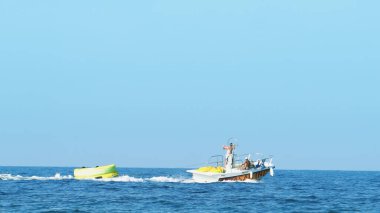 Halkidiki, Yunanistan - 25 Haziran 2018: Tropikal turkuaz körfezde aşırı süratli sürat teknesi su sporları küfürü