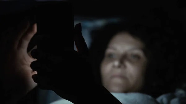 Самотня Жінка Використовує Свій Мобільний Телефон Вночі Лежачи Ліжку — стокове фото