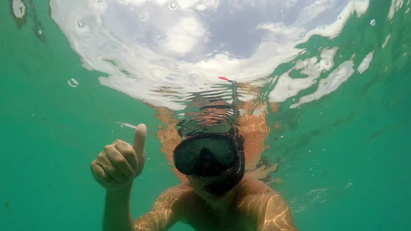 바다에서 마스크를 사용하여 사람을 미끄러지게 손가락으로 올바른 표시를 — 스톡 사진