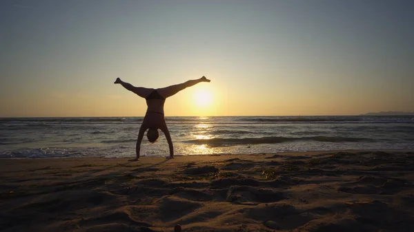 日没時に海岸で健康な女性体操を行う — ストック写真
