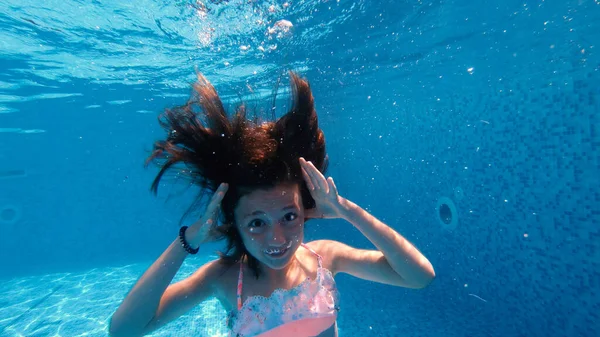 Šťastná Holčička Dělá Legrační Grimasy Pod Vodou Bazénu — Stock fotografie