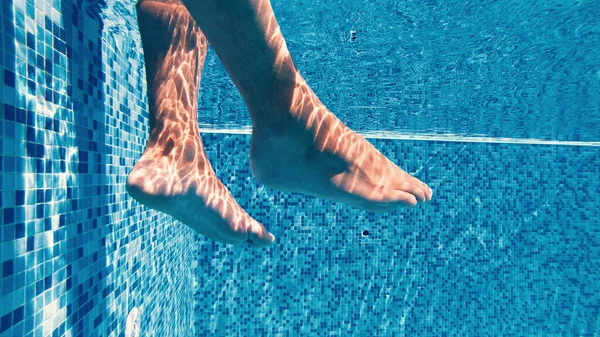 リラックスする前にプールで彼の足をスイング男性の遅い動き — ストック写真