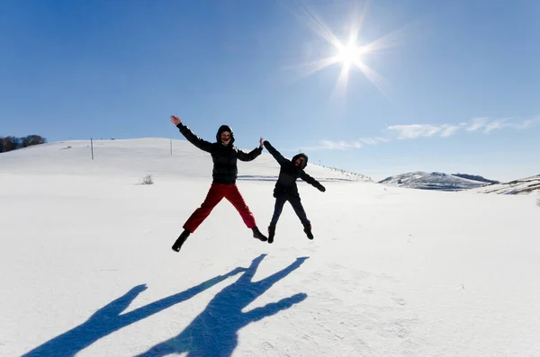 Two Friends Joyfully Jump Sky Snow Drifts Winter — Stock Photo, Image