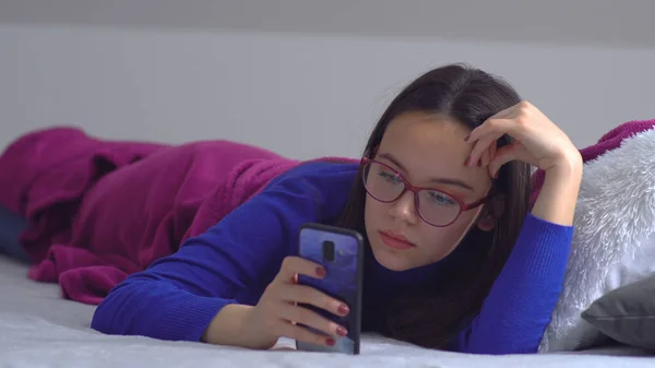 Θετικό Κορίτσι Γυαλιά Χρησιμοποιούν Κινητό Τηλέφωνο Στο Κρεβάτι — Φωτογραφία Αρχείου