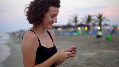 Gün batımında güneşli sahilde dans eden tatlı kız.