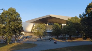 Olimpiyat Parkı 'ndaki Olimpiyat Kulesi (Olympiapark), ağaç dalları arasında gün batımını yer, Münih, Almanya
