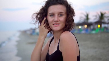 Gün batımında güneşli sahilde dans eden tatlı kız.