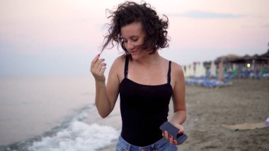 Gün batımında güneşli sahilde dans eden tatlı kız.