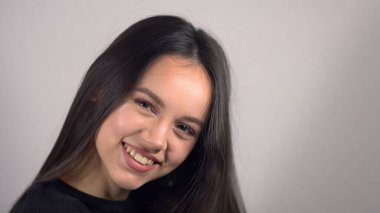 Neşeli baştan çıkarıcı genç bayan kameraya olumlu gülümsüyor.