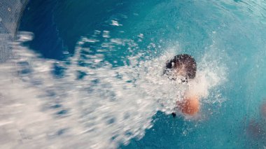 Havuzdaki bir kadının sırtına su püskürtüyor.