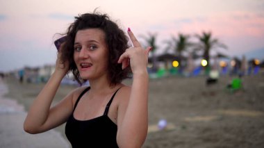 Gün batımında güneşli sahilde dans eden tatlı kız.