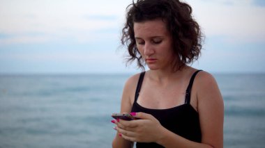 Gün batımında güneşli sahilde dans eden tatlı kız.