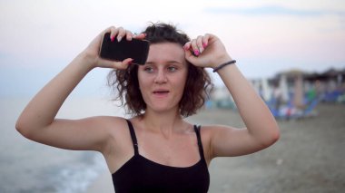 Gün batımında güneşli sahilde dans eden tatlı kız.