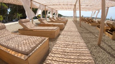 Yaz tatili tatil beldesi kumlu bir sahilde beyaz çadır mavi güneşli gökyüzünün arka planında