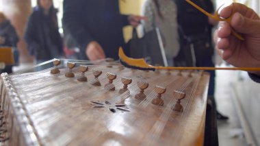 Sokak müzisyeni dışarıda santur müzik enstrümanı çalıyor.