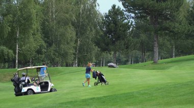 Bansko, Bulgaristan - 12 Eylül 2019: Oyuncular yaz günü mükemmel golf sahasında yürüyen ve ekipman arabaları, ağır çekim