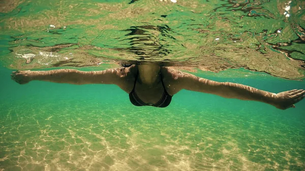 一个带着眼镜和比基尼的性感女人躺在海面上悠闲自在地躺着 从漂浮在波浪上挥动的相机看到了半边水下的凹凸圆顶镜头 — 图库照片