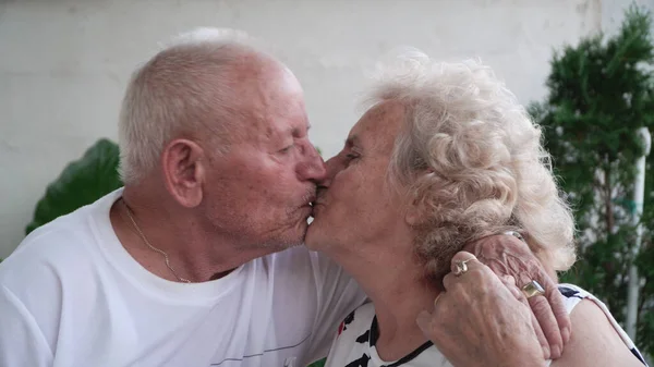 Coppia Anziani Che Baciano Casa Seduti Sul Portico Pensionamento Concetto — Foto Stock