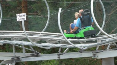 Bansko, Bulgaristan - 20 Ağustos 2019: Erkek ve kız yaz eğlence treni yolculuğunun tadını çıkarıyorlar. Kırmızı bir lunaparkta heyecanlı bir yolculuktan zevk alırken komik bir ifadeleri vardır.