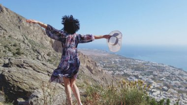 Perissa köyü manzaralı Antik Thera, Santorini 'de kadın güneşli havanın tadını çıkarıyor.