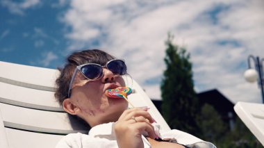 Havuz partisinde lolipopu olan genç kız eğleniyor.