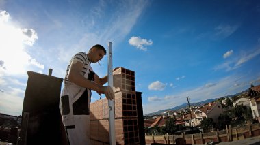 Kocani, Macednoia - 10 Ekim 2018: İnşaat işçisi inşaat sahasına tuğla kuruyor