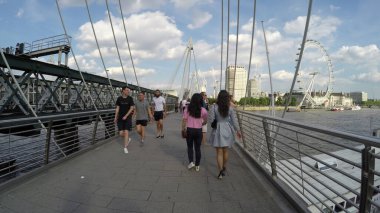 Londra, İngiltere - 17 Haziran 2017: Londra Gözü manzaralı bir köprüde turistler 