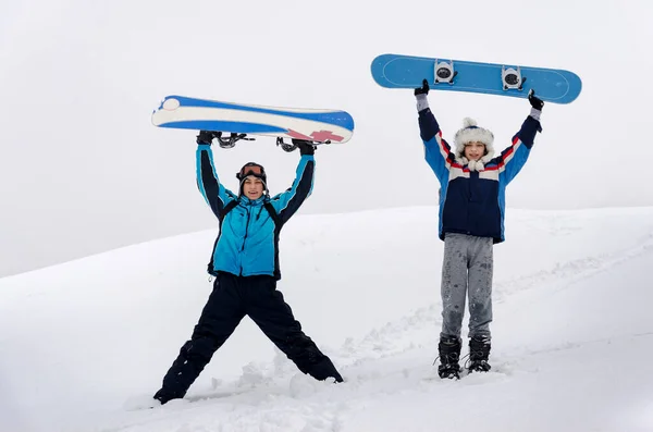 Two Snowboarders Raised Arms Standing Hold Snowboard Snow Mountain Slope — Stock fotografie