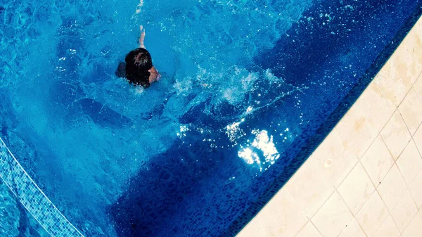 豪華なリゾートでプールでの小さな女の子のダイビングの空中ビュー — ストック写真
